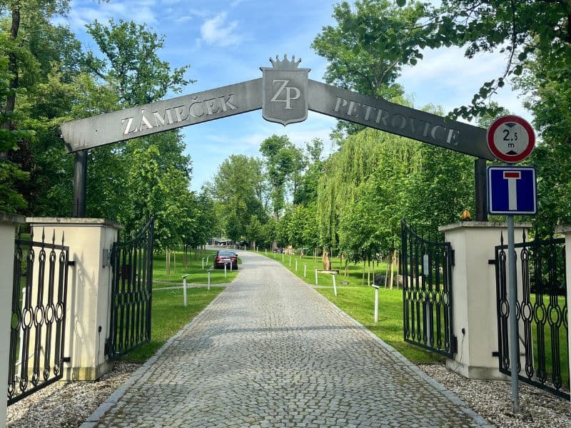 Vstupní brána do Zámečku Petrovice – elegantní vstup do zámeckého areálu s parkem, wellness a historickým ubytováním v srdci Slezska.