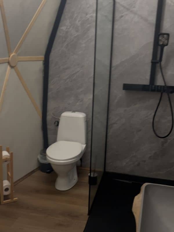 Čistá a prostorná koupelna v glamping stanu v Colony Glamping Brdy s toaletou a sprchou s masážními tryskami.