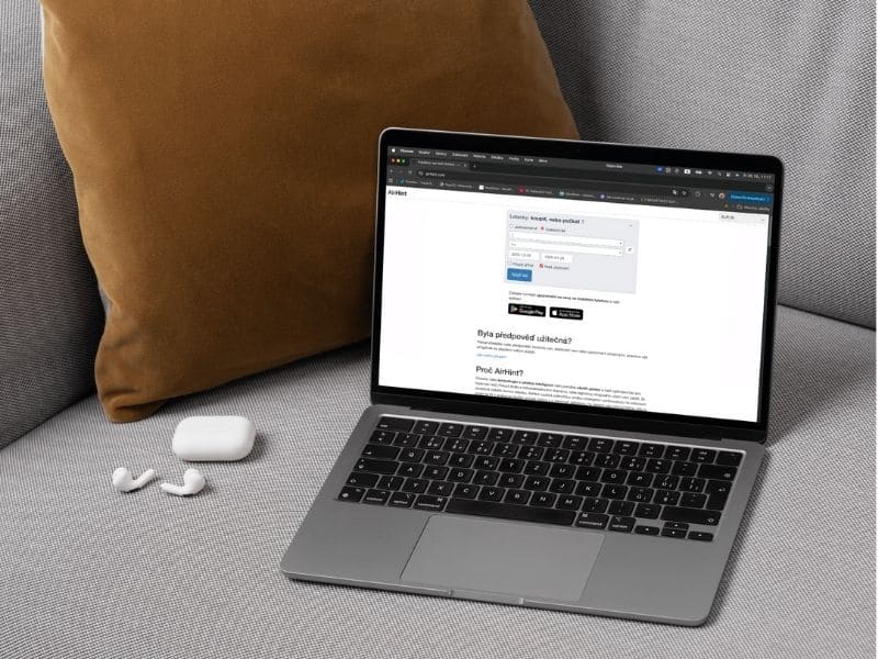 Laptop s otevřenou stránkou AirHint na gauči – ukázka, jak umělá inteligence pomáhá při chytrém hledání letenek.