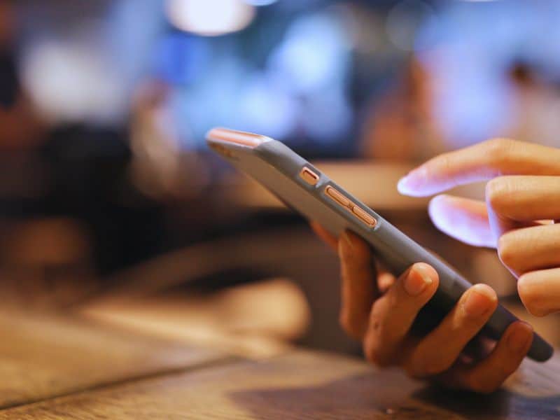 Mobilní telefon v ruce – aktivace eSIM pro cestování před odletem.