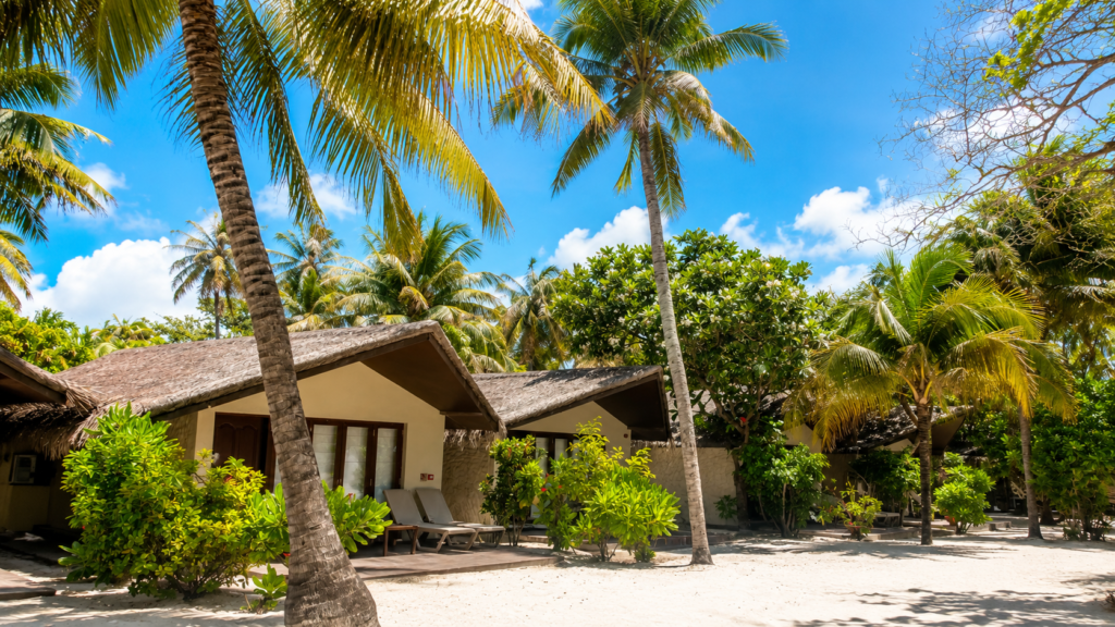Plážové vilky resortu Adaaran Select Hudhuran Fushi na Maledivách obklopené palmami a tropickou zelení
