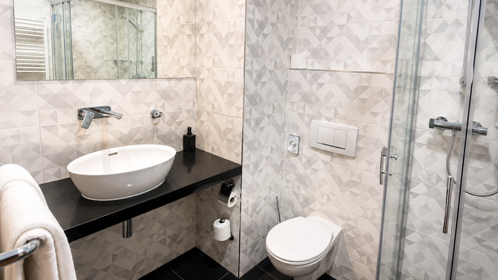 Koupelna v Ramada Airport Hotel Prague se sprchovým koutem, umyvadlem a moderními obklady